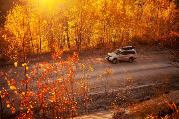Mitsubishi Pajero on scenic autumn road in mountains