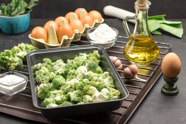 Foto mescolare broccoli e cavoli di bruxelles in un pallet di metallo alimentare uova aglio e cipolle farina e burro