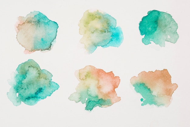 Photo mix of brown, green and aquamarine paints on white paper