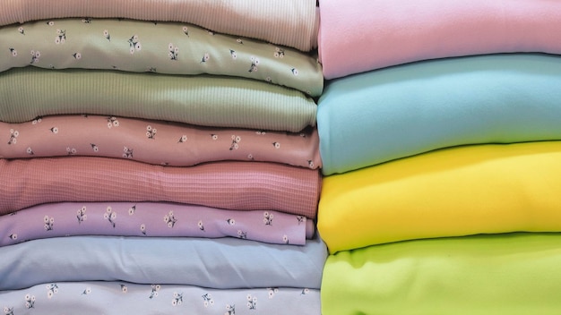 Смешайте красочные висящие текстильные ткани на вешалке Текстура разноцветных тканей крупным планом