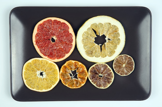 Mix different pieces of dried citrus fruit on a plate

