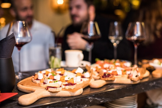 Mix of different snacks and appetizers. Spanish tapas on a black stone space. bar. Space for text. Deli, sandwiches, olives, sausage, anchovies, cheese, jamon, pepper, tomatoes. Top view