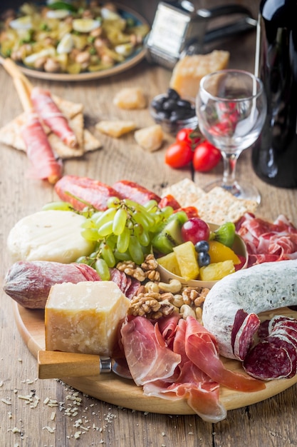 Foto mix di diversi snack e antipasti. tapas spagnole o vino italiano impostato su un piatto di legno