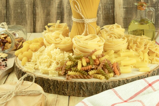 A mix of different types of pasta on a wooden background