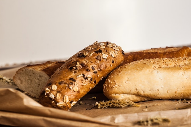 Foto mix di diverse varietà di pane che giace su un tavolo di legno