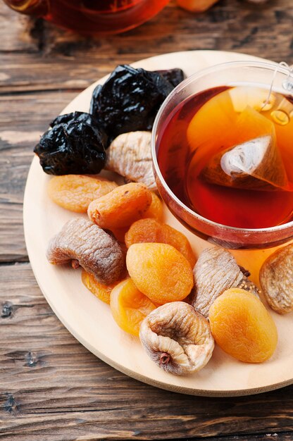 Mix of dried fruits with cup of black tea