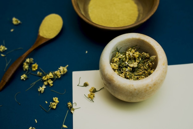 Mix dry chamomile flowers in a marble mortar to create cosmetics and a face scrub