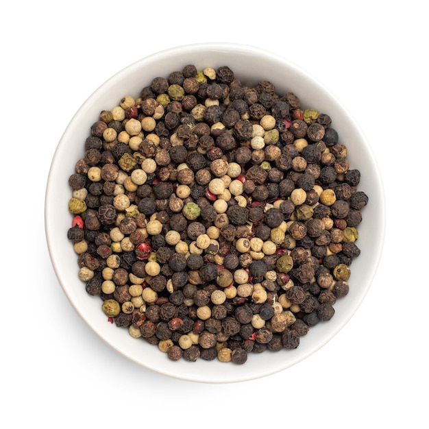 Mix of four types peppercorns in bowl isolated on white background Top view