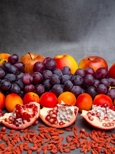 Mix of fresh fruits and berries rich with resveratrol raw food ingredients nutrition background red fruits