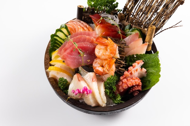 Mix fresh sashimi Salmon fish shrimp tuna saba and squid on tub isolated on white Japanese food on restaurant table Japanese food traditional style