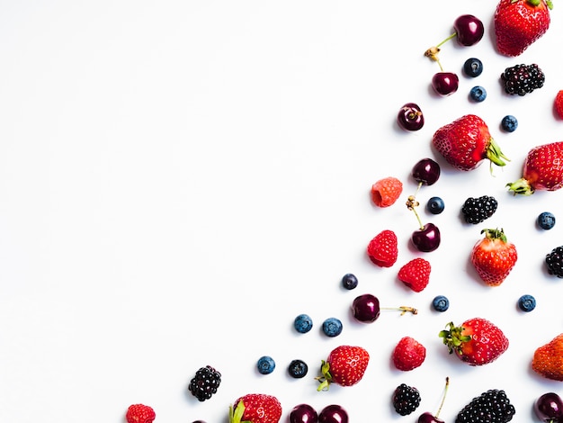 Photo mix of fresh tasty berries on right of white background