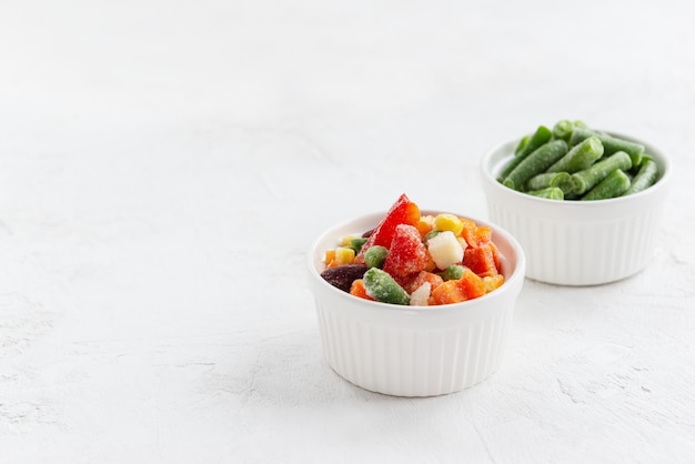 Mix of frozen vegetables in white bowls