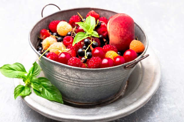 Mix fruit and berries in grey metal bowl