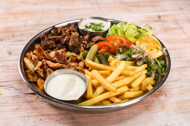 Mix Laham beef chicken dajaj shawarma platter with fries and salad served in dish isolated on table top view fastfood