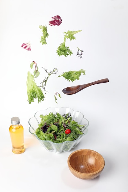 Foto mescolare insalata di verdure a foglia verde viola lattuga ciotola di vetro elevata caduta volante