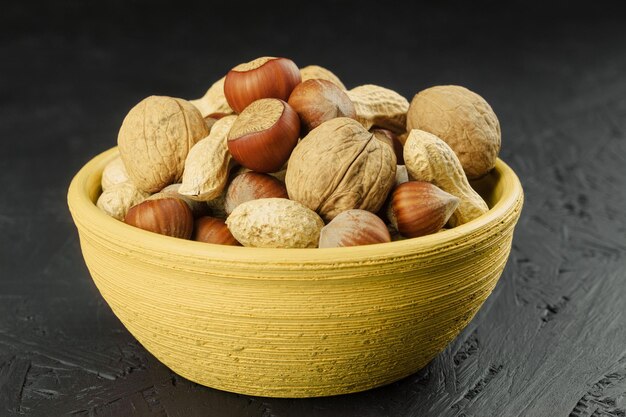 A mix of nuts in a shell in a clay plate