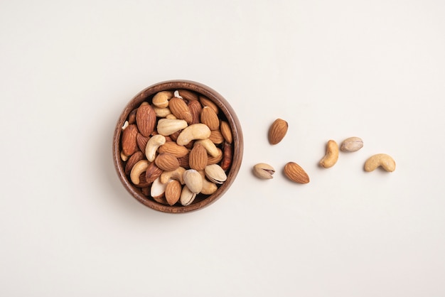 Mix of nuts on wooden bowl on light background