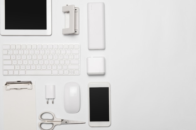 Mix of office supplies and gadgets on white background