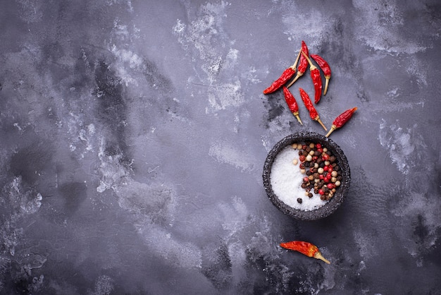 Mix of peppers and salt on gray background