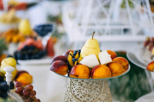 Mix Perzik druiven meloen peer pruim Stukjes fruit op een bord op tafel