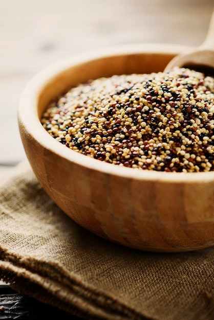 Mix of raw red, white and black quinoa on thw wooden table