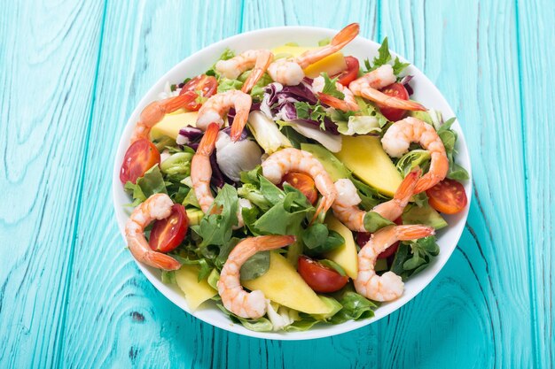 Mix of salad with shrimps avocado and cherry tomatoes Healthy food background