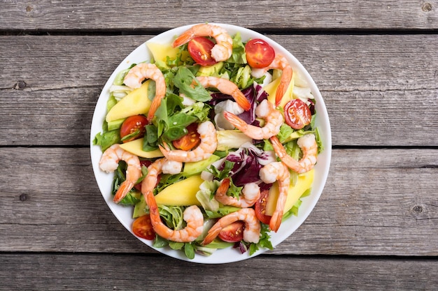 Mix of salad with shrimps avocado and cherry tomatoes Healthy food background