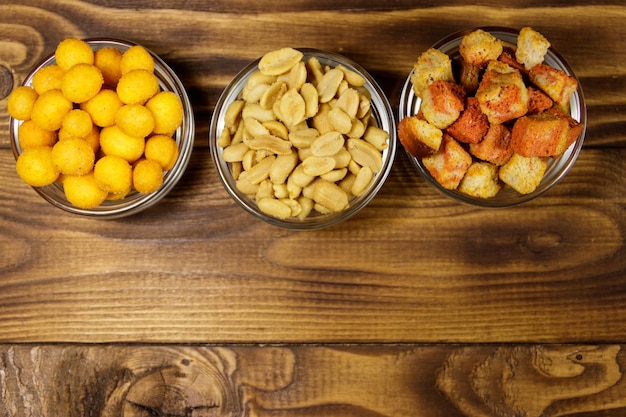 Mix of snacks for beer on wooden table. Top view