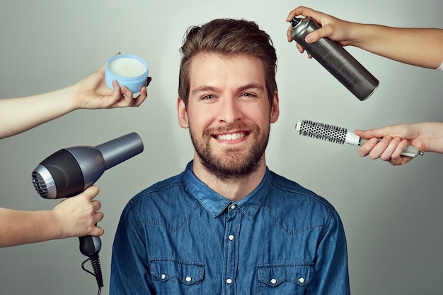 Mix up your look with a makeover Studio portrait of a young man getting a hair makeover against a gray background