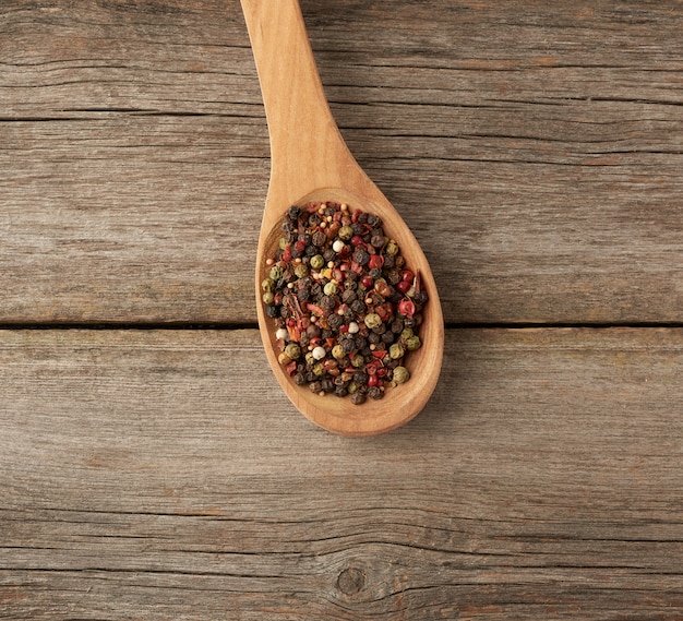 Mix van droge ballen van verschillende paprika's in een houten lepel