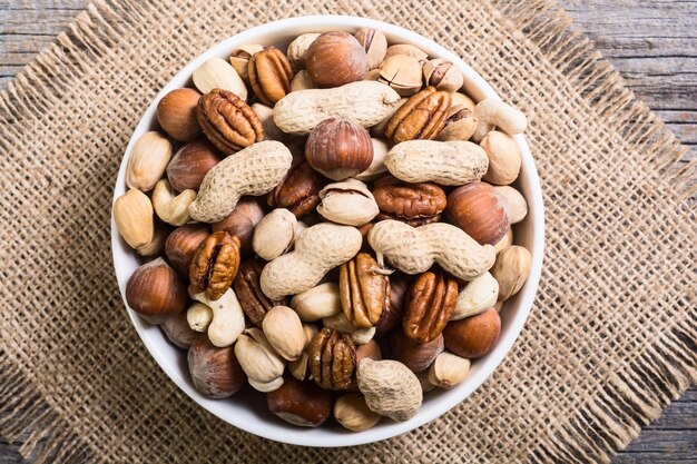 Mix van noten in bord pecannoten, hazelnoten, pistachenoten, cashewnoten en pinda's