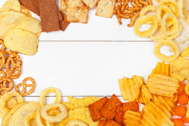 Foto mix van snacks: pretzels, crackers, chips en nacho's op tafel