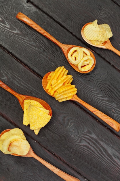 Mix van snacks: pretzels, crackers, chips en nacho's op tafel