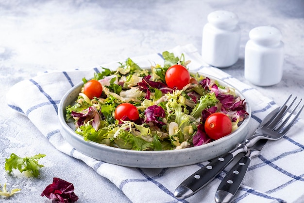 Mix van verse groene bladeren en tomaten op een bord Gezond eten en dieet concept