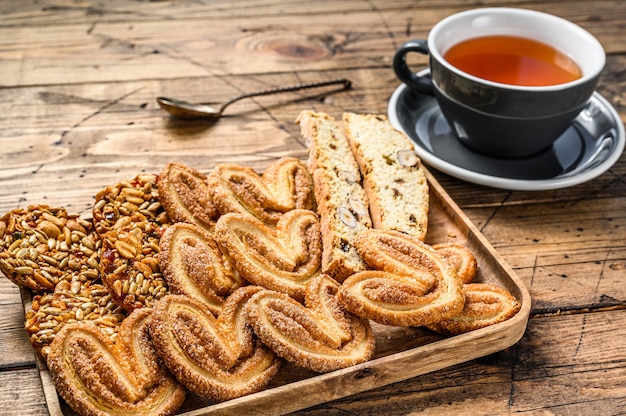 Mix van zoete koekjes met een kopje thee. houten achtergrond. Bovenaanzicht.