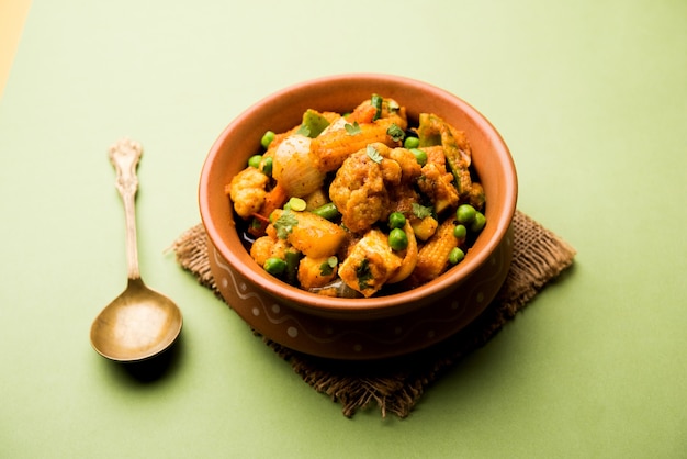 Смешайте овощное карри - индийский рецепт основного блюда содержит морковь, цветную капусту, зеленый горошек и фасоль, бэби-кукурузу, перец и панир или творог с традиционной масалой и карри.
