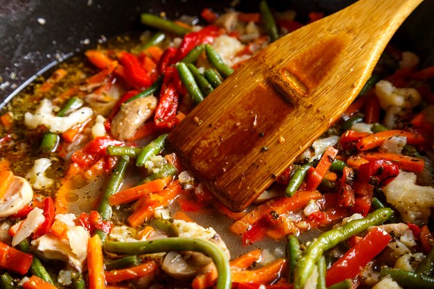 Mix the vegetables in the pan with a wooden spatula