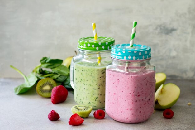 Mix vers fruit smoothie en groene smoothies op een grijze steen of leisteen