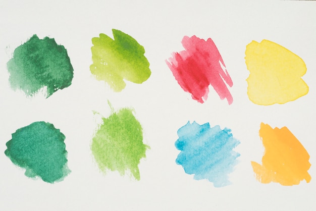 Mix of yellow, green, azure, red and orange paints on white paper