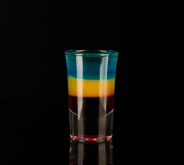 Mixed alcoholic liquor in a shot glass isolated on a black background