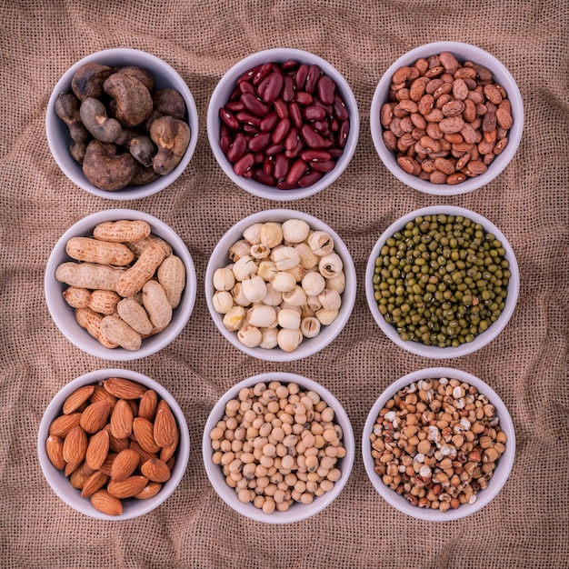 Mixed beans and lentils in the white bowl  on brown background. 