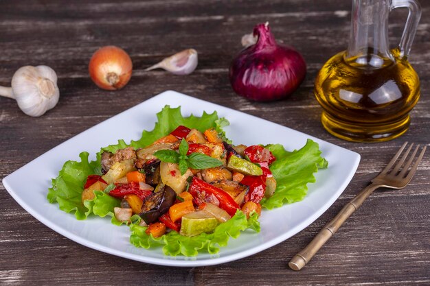 Mixed boiled vegetables on a white plate close up