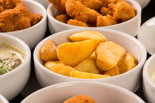 Mixed brazilian snacks, including pastries, fried chicken, salads, soups, fries and kibe