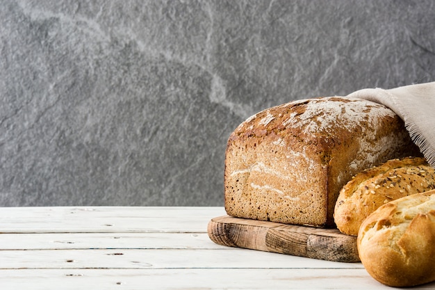 Mixed bread on white wooden background Copyspace