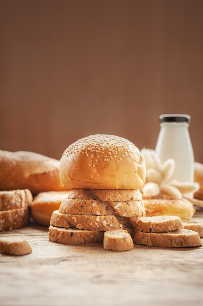 Mixed breads background on wooden table.