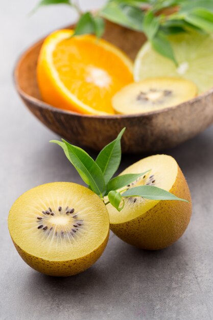 Смешанные лимоны цитрусовых, апельсин, киви, лаймы на сером фоне.
