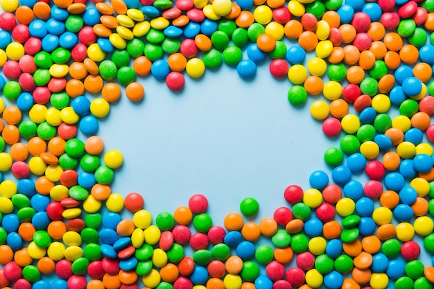 색깔이 있는 배경에 있는 다채로운 사탕의 혼합 컬렉션