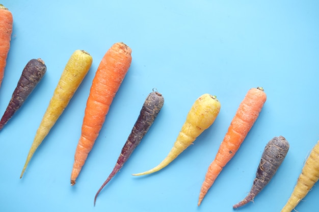 Photo mixed colorful carrot on blue background