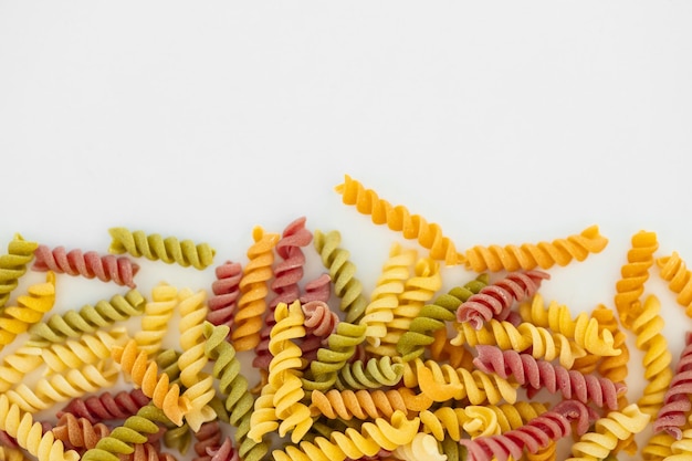 Mixed colorful pasta on white background