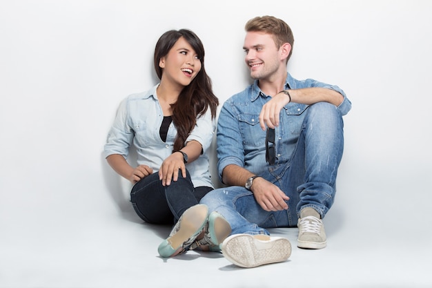 Photo mixed couple sitting on the floor. man embracing woman